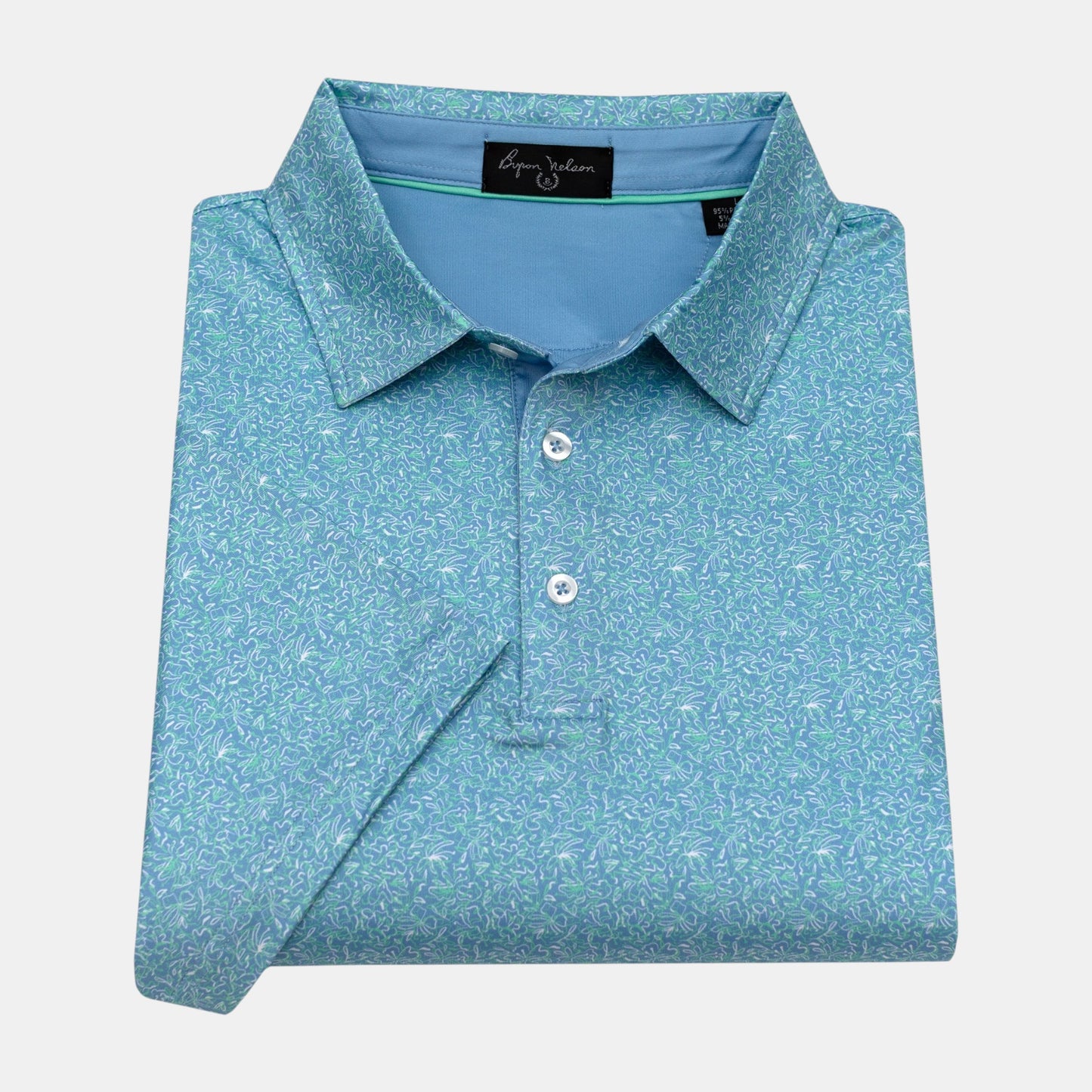 Byron Nelson Coastal Classic polo shirt in blue with a white and green abstract floral print. Made of polyester/spandex.