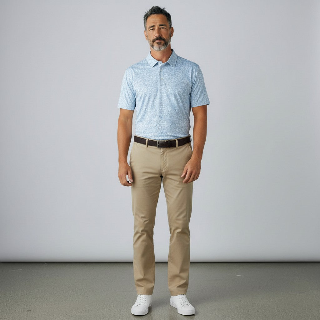 Byron Nelson light blue dog print golf polo shirt worn by a man with khaki trousers and white sneakers.