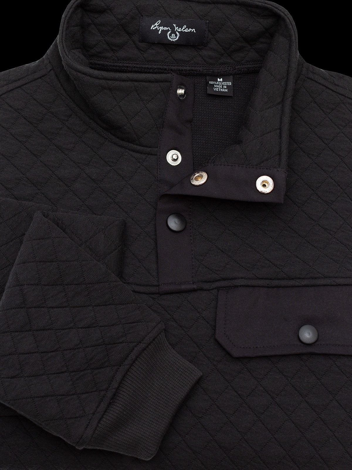 Byron Nelson black quilted pullover with diamond pattern, snap placket, chest pocket, and ribbed cuffs. Cotton-polyester blend.