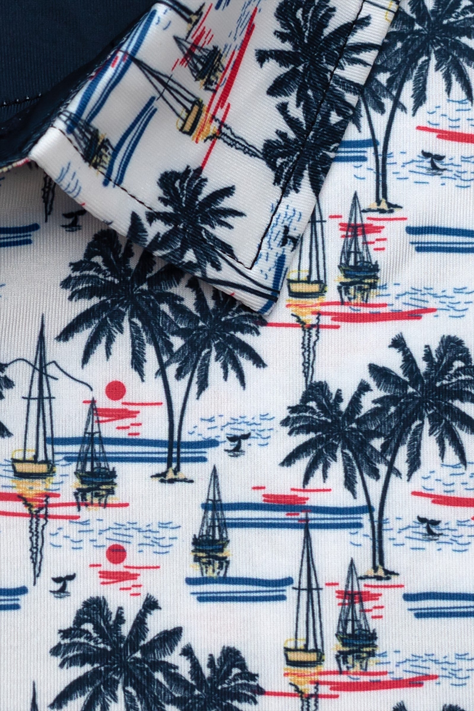 Byron Nelson white polo with navy palm trees, sailboats, and red sunset print. Moisture-wicking polyester-spandex blend.