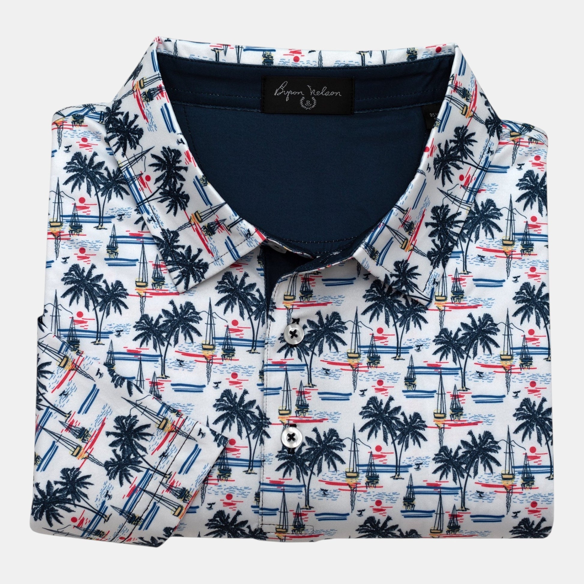 Byron Nelson white polo with all-over palm trees, sailboats, and sunset print. Moisture-wicking fabric.