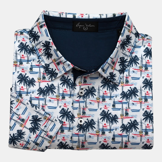Byron Nelson white polo with all-over palm trees, sailboats, and sunset print. Moisture-wicking fabric.