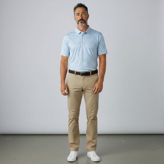 Byron Nelson light blue dog print golf polo shirt worn by a man with khaki trousers and white sneakers.