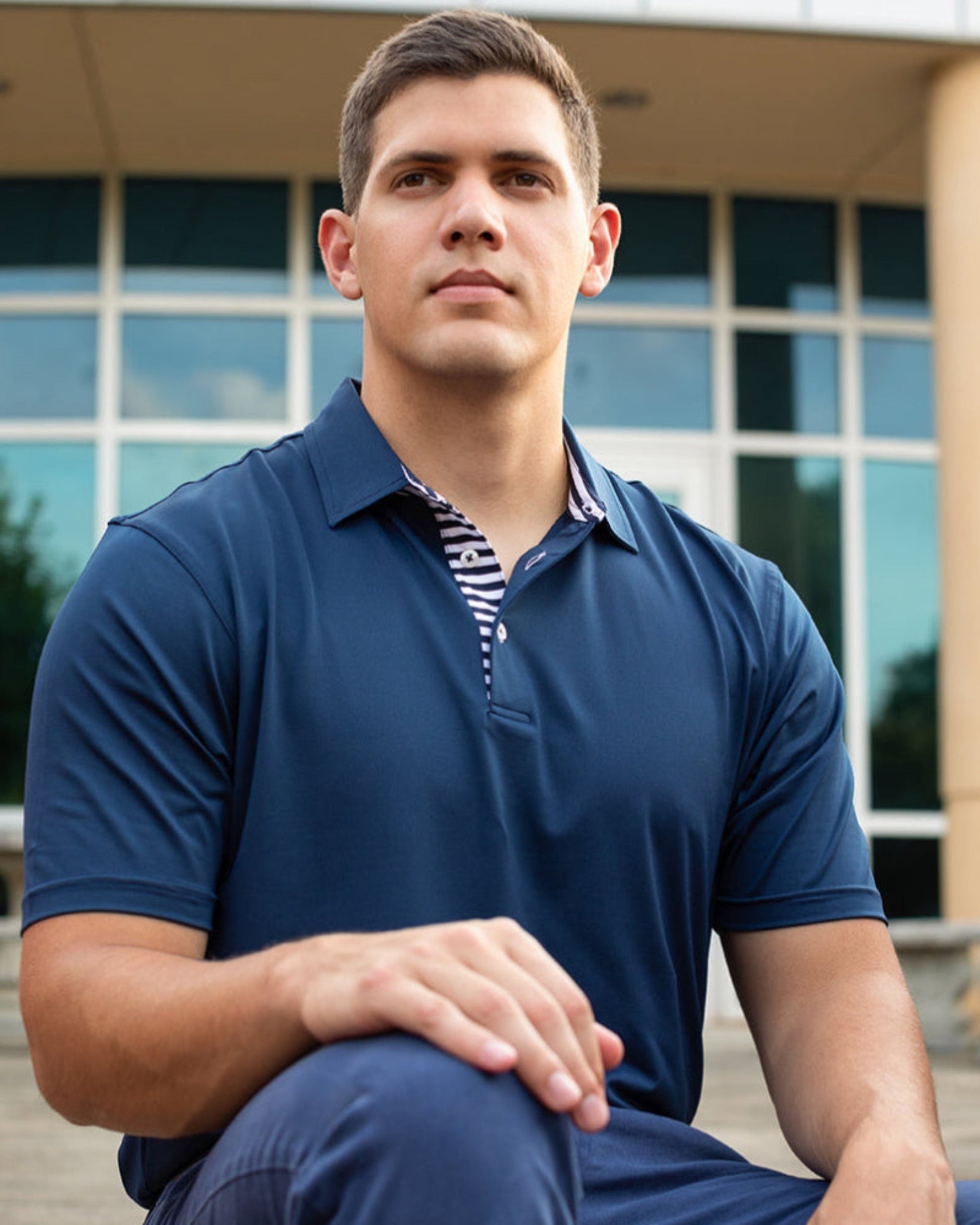 Byron Nelson Miami Polo in navy blue, featuring a striped placket and neck band. Made from a performance polyester-spandex blend.