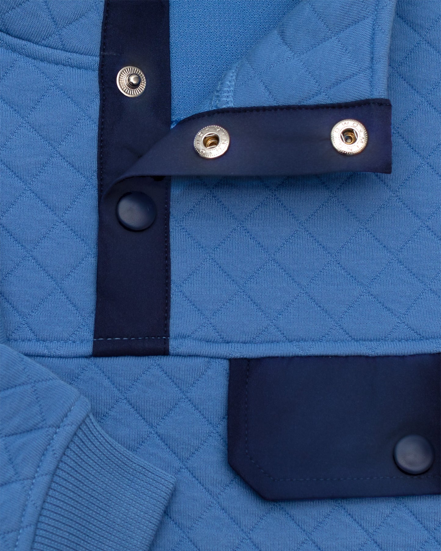 Byron Nelson sky blue quilted pullover with navy accents, snap placket, and chest pocket. Cotton-polyester blend.