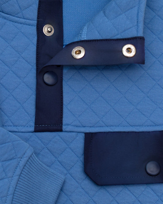 Byron Nelson sky blue quilted pullover with navy accents, snap placket, and chest pocket. Cotton-polyester blend.