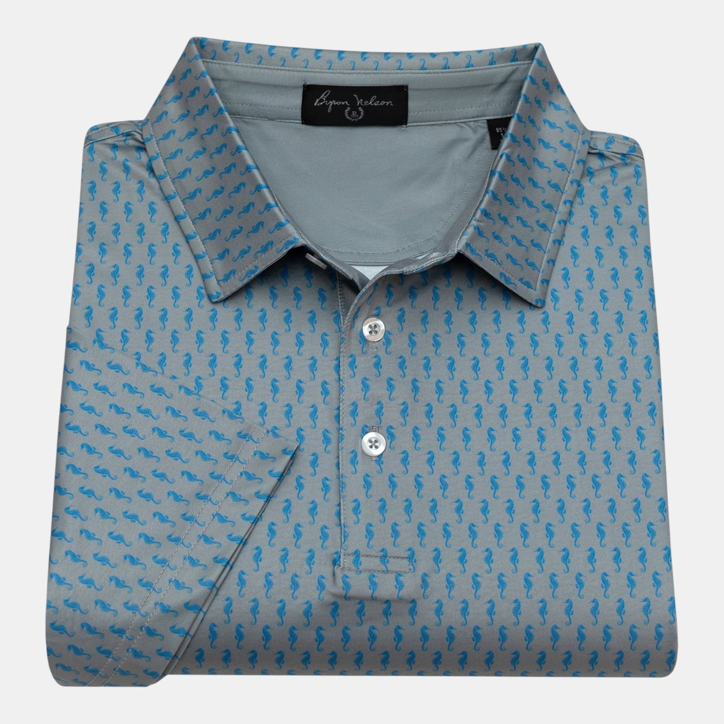 Byron Nelson grey polo shirt with blue seahorse print, short sleeves, and button collar. Made from polyester/spandex performance fabric.
